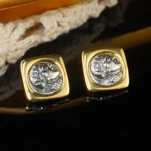 Close-up detail of vintage court-style square earrings with silver portrait relief