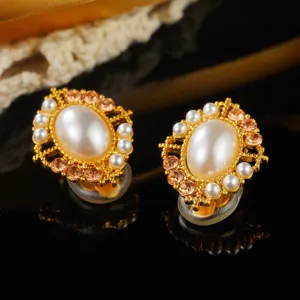 Detailed view of vintage court-style gold earrings with white pearls and amber stones