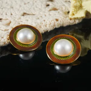Detailed macro view of vintage court-style enamel earrings featuring a large central pearl