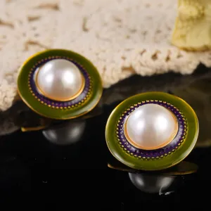 Close-up macro view of vintage olive green enamel stud earrings with pearl center