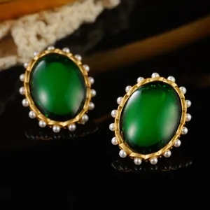 Macro view of vintage emerald green oval earrings with elegant pearl border and gold-tone finish