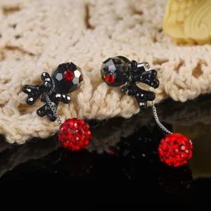 Close-up detail of gothic earrings with red rhinestone balls and black faceted beads