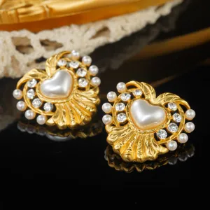 Close-up of vintage gold heart earrings with faux pearls and sparkling rhinestones
