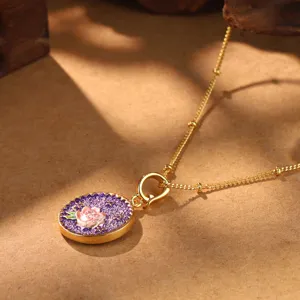 Detailed macro shot of a vintage gold necklace featuring a rose and purple enamel pendant.