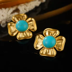 Close-up of vintage golden flower stud earrings with elegant turquoise center stones