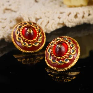 Close-up detail of vintage court style red enamel earrings with gold rope border