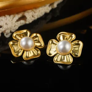 Macro detail view of elegant vintage gold floral earrings with central white pearls