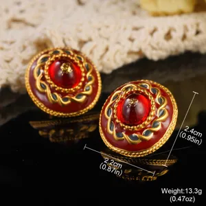 Detailed macro view of vintage palace style red enamel earrings with gold foil accents