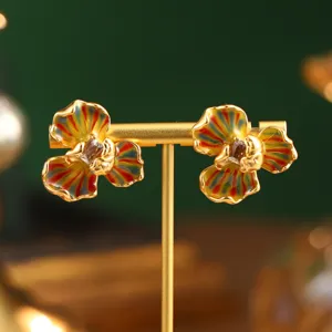 Gros plan détaillé de boucles d'oreilles fleurs en émail style peinture Monet.