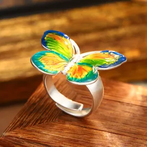 Close-up of vintage enamel butterfly ring with vibrant colors and adjustable band.