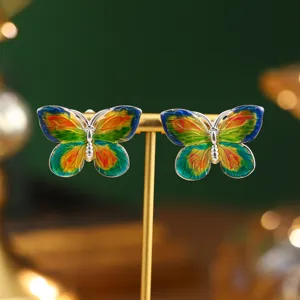 Detailed view of colorful enamel butterfly earrings inspired by Monet's oil paintings.
