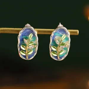 Détail macro de boucles d'oreilles en émail français avec style Monet et motifs feuilles