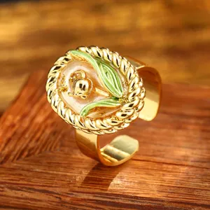 Close-up of vintage flower ring with green enamel leaf and gold lily detail