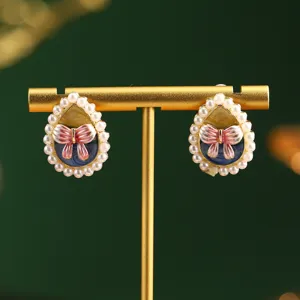 Close-up detail of vintage Monet-inspired oil painting earrings with pearls and bow