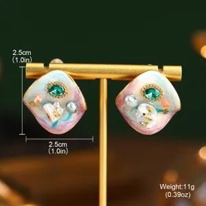 Détail de boucles d'oreilles émaillées style peinture à l'huile avec perles et gemme