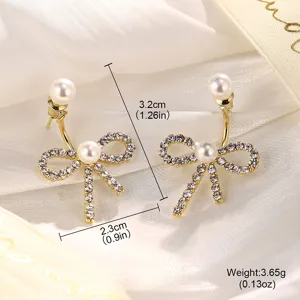 Makroansicht eleganter goldener Schleifenohrringe mit Strasssteinen und Perlen