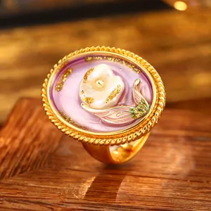 Close-up of vintage baroque flower ring with purple enamel and natural pearl.