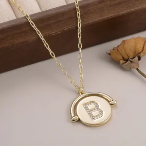 Vue détaillée d'un collier avec pendentif circulaire doré et initiale B en strass brillant