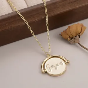 Vue détaillée en gros plan d'un collier en or avec pendentif rond gravé Gorgeous