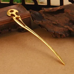 Primer plano detallado de una elegante horquilla dorada con patrón de nubes de estilo vintage