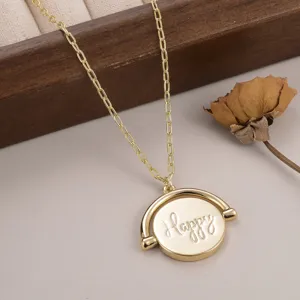 Vue rapprochée détaillée du collier doré avec pendentif circulaire gravé Happy