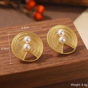 Détail macro de boucles d'oreilles rondes dorées avec perles et découpe géométrique