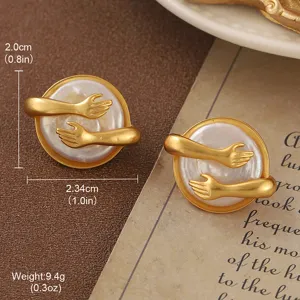 Detailed view of vintage gold hugging hands earrings with pearl center and measurements.