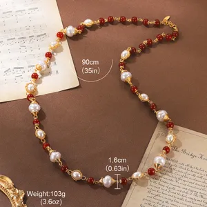 Close-up of vintage long necklace with pearls and red beads showing 90cm length and weight