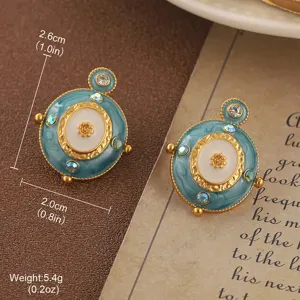 Detailed close-up of vintage teal enamel earrings with golden floral patterns and gems