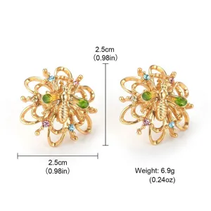 Detail view of vintage gold bee earrings with colorful crystals and size markings.