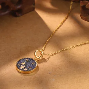 Detailed view of vintage gold necklace with floral enamel pendant and warm lighting