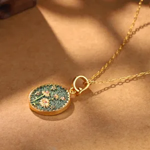 Detail view of vintage palace style gold necklace featuring a floral enamel pendant
