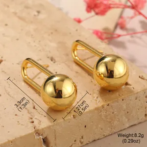 Détail rapproché de boucles d'oreilles boules dorées avec mesures précises
