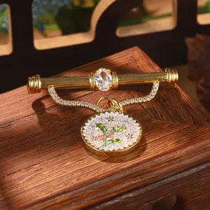 Macro view of vintage court style gold brooch enhancer with floral enamel pendant detail
