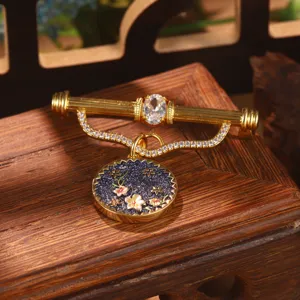 Detailed view of a vintage Chinese style birth flower brooch with enamel floral design