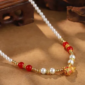 Detail einer Vintage Perlenhalskette im chinesischen Stil mit roten Perlen und Goldanhänger