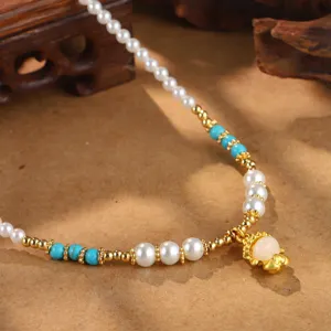 Vintage Lotus Friedensschloss Kette mit weißen Perlen und türkisen Perlen im Detail