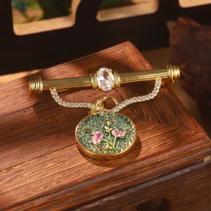 Close-up of vintage Chinese style flower brooch with green enamel and crystal details