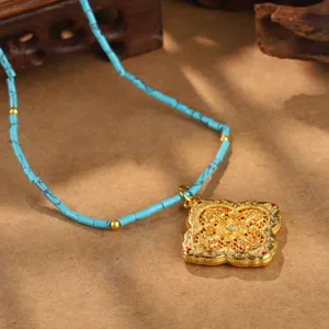 Nahaufnahme eines goldenen filigranen Anhängers mit Türkisperlen-Halskettendetails