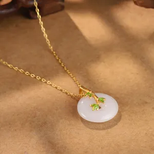 Detailaufnahme der Vintage-Halskette mit Bambus-Gold-Anhänger und weißem Jade-Pendant