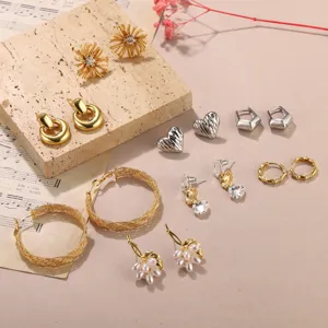 Collection variée de boucles d'oreilles clous et créoles en métal aux motifs cœur et fleurs