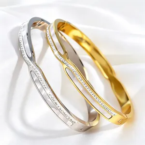 Detailopname van roestvrijstalen armbanden met fonkelende strass-steentjes en schelp.
