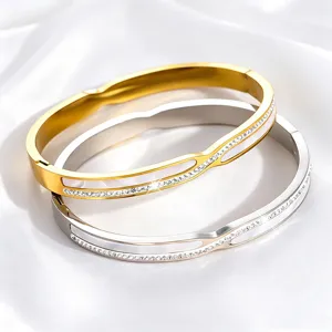 Detailweergave van roestvrijstalen armbanden met kristallen en wit parelmoer.