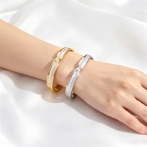Elegante kruislingse roestvrijstalen armbanden met parelmoer inleg op de pols