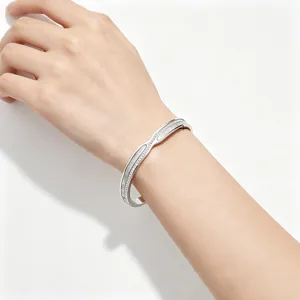 Detail van een zilveren roestvrijstalen armband met witte schelp gedragen om de pols