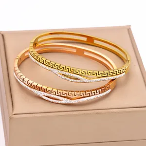 Vista dettagliata di bracciali in acciaio 316 con motivi a greca vintage e strass luccicanti