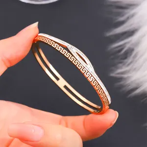 Primo piano del bracciale in acciaio titanio oro rosa con motivo greco e strass