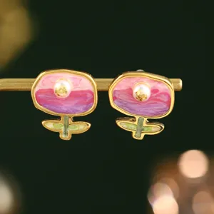 Détail macro de boucles d'oreilles fleurs en émail et perle naturelle style