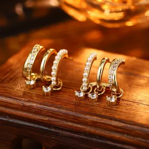 Detailansicht goldener Mehrschicht-Ohrringe mit weißen Perlen und Zirkonia-Steinen.