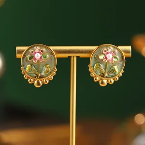 Detailed macro shot of vintage flower earrings with pearls on a gold jewelry stand.
